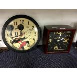 Two wall hanging clocks one depicting Mickey Mouse.