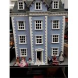 A large dolls house together with dolls and furniture.