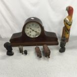 A mantle clock with other wooden figures.