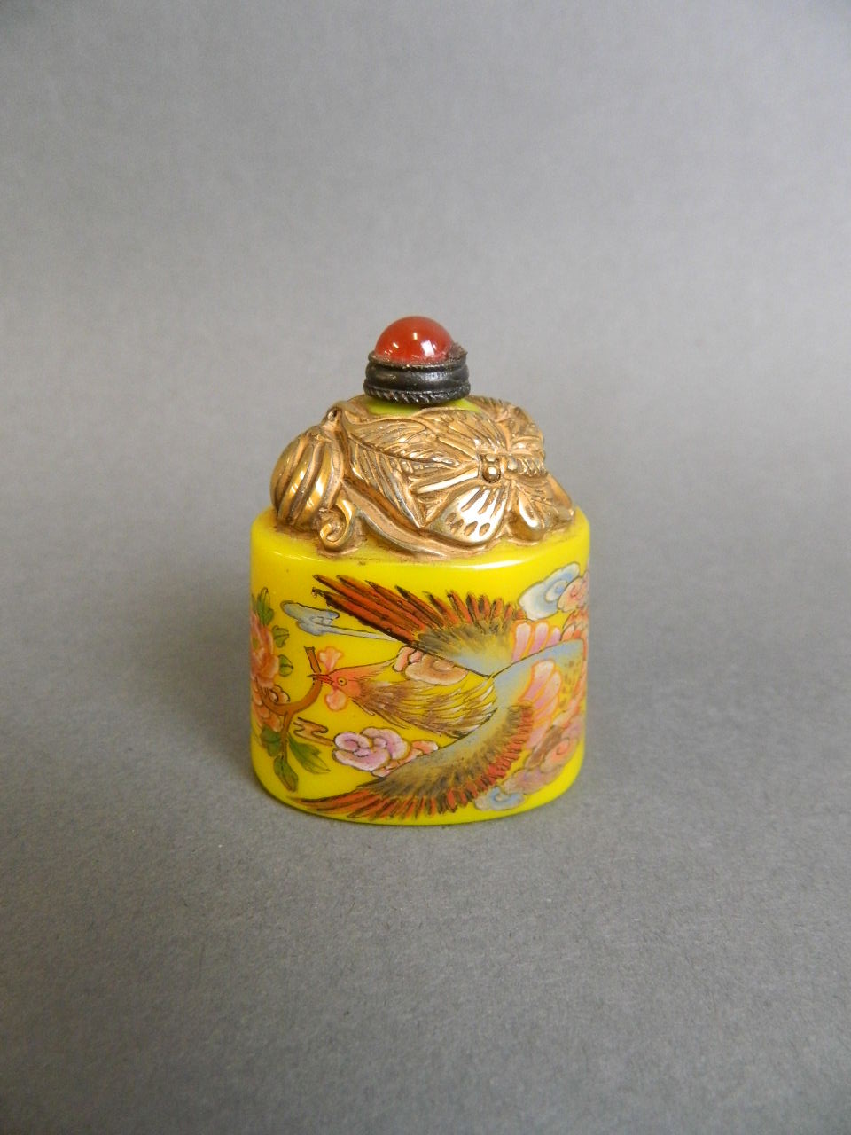 A Peking glass snuff bottle with enamelled phoenix decoration on a yellow ground, 2" high