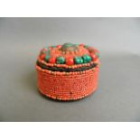 A Tibetan bead and linen trinket casket with coral and turquoise style beads, 4" diameter