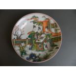 A Chinese famille verte enamelled porcelain dish decorated with women playing board games in a