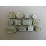 A collection of twelve small Chinese bronze seals, each depicting one of the zodiac animals, largest