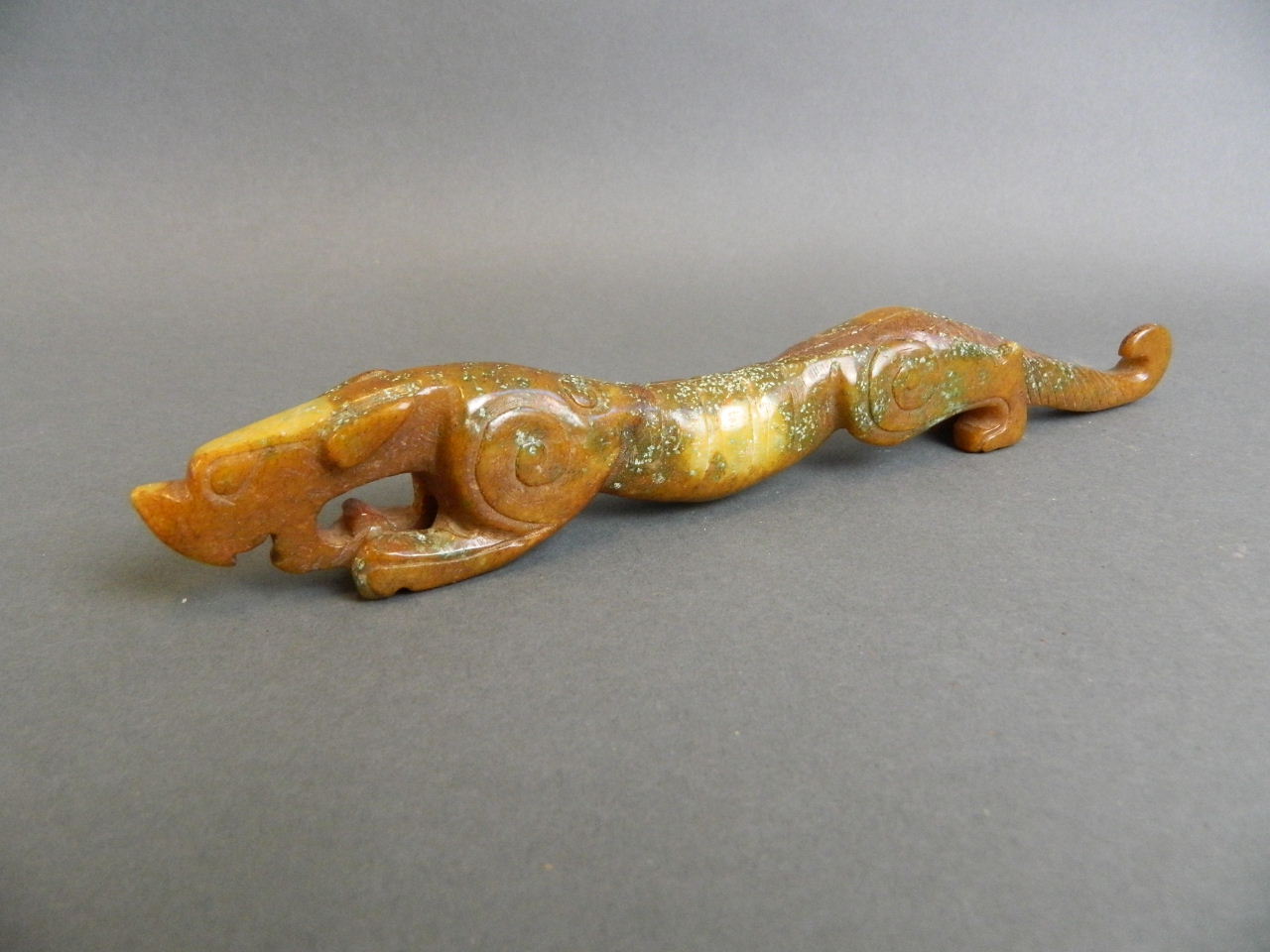 A Chinese carved hardstone ornament in the form of a dragon, 9½" long