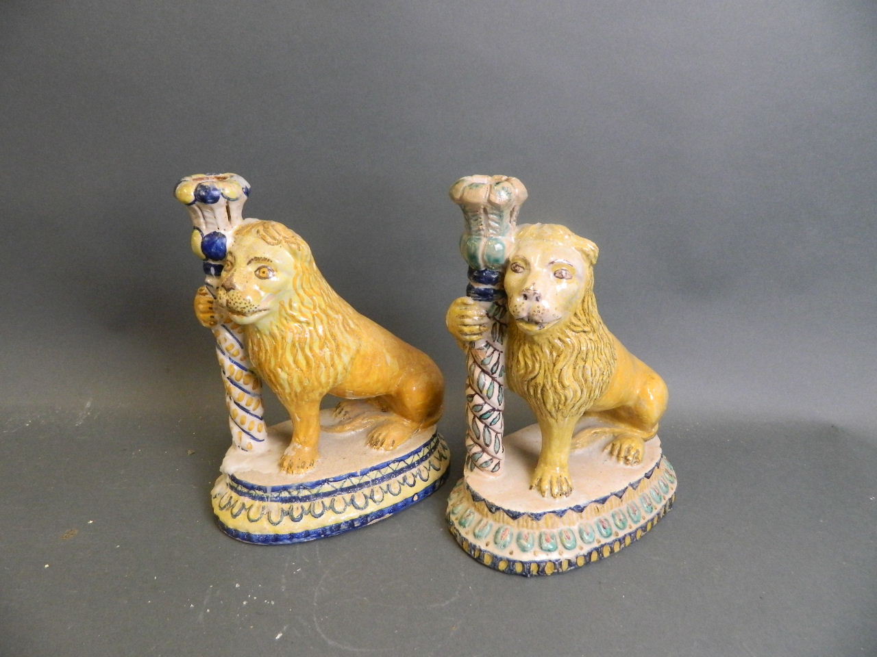 A pair of Spanish faience Majolica candlesticks in the form of lions, 9½" high