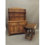 An oak dresser with shelved upper section over two drawers and cupboards with linen fold decoration,