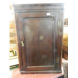 A Georgian mahogany hanging corner cupboard with fielded panel door, 25" x 37"