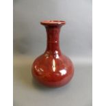 A large Chinese sang de boeuf glazed porcelain vase with flared rim and ribbed neck, 12" high