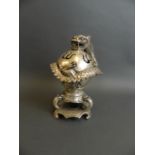 A Chinese silvered metal censer in the form of a coiled dragon around a pearl, raised on tripod