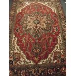 A Persian Tabriz carpet with floral design on a red field within a black ground border, 104" x 74"