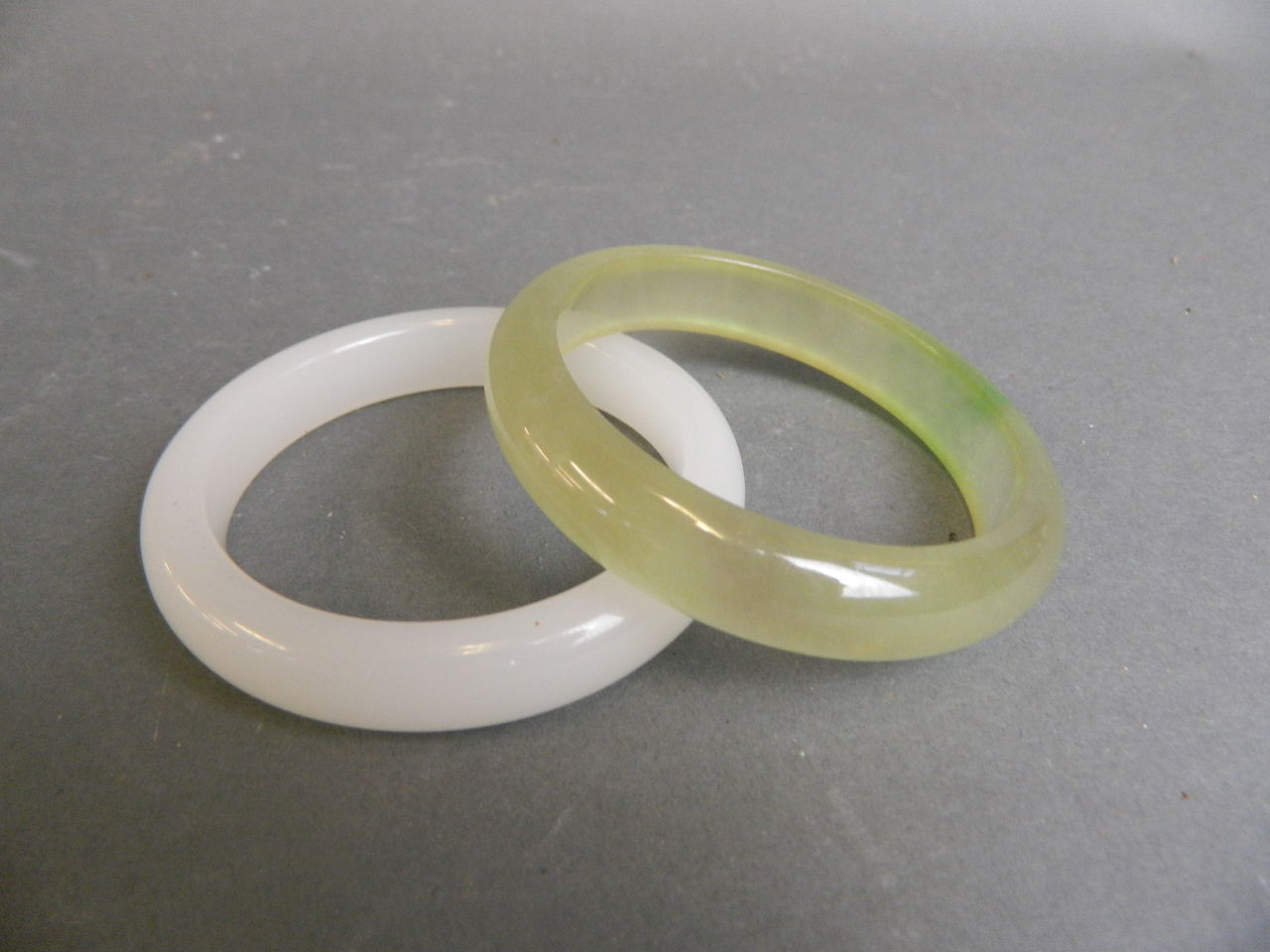 A Chinese white jade bangle, and another similar, 3" diameter