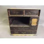 A Japanese lacquered table top cabinet with multiple drawers decorated with gilt on a black