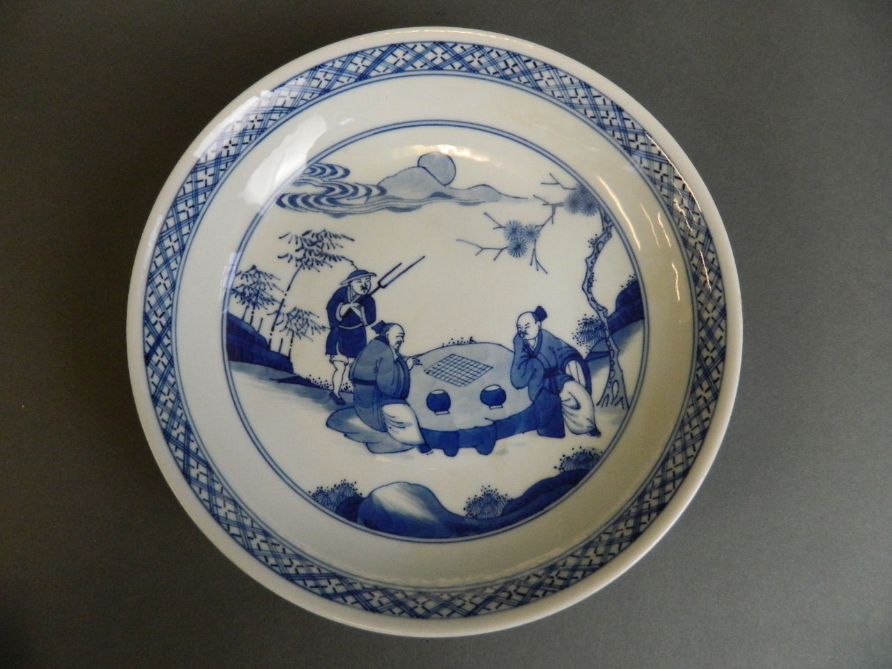 A Chinese blue and white porcelain dish decorated with gentlemen playing chequers, 6 character