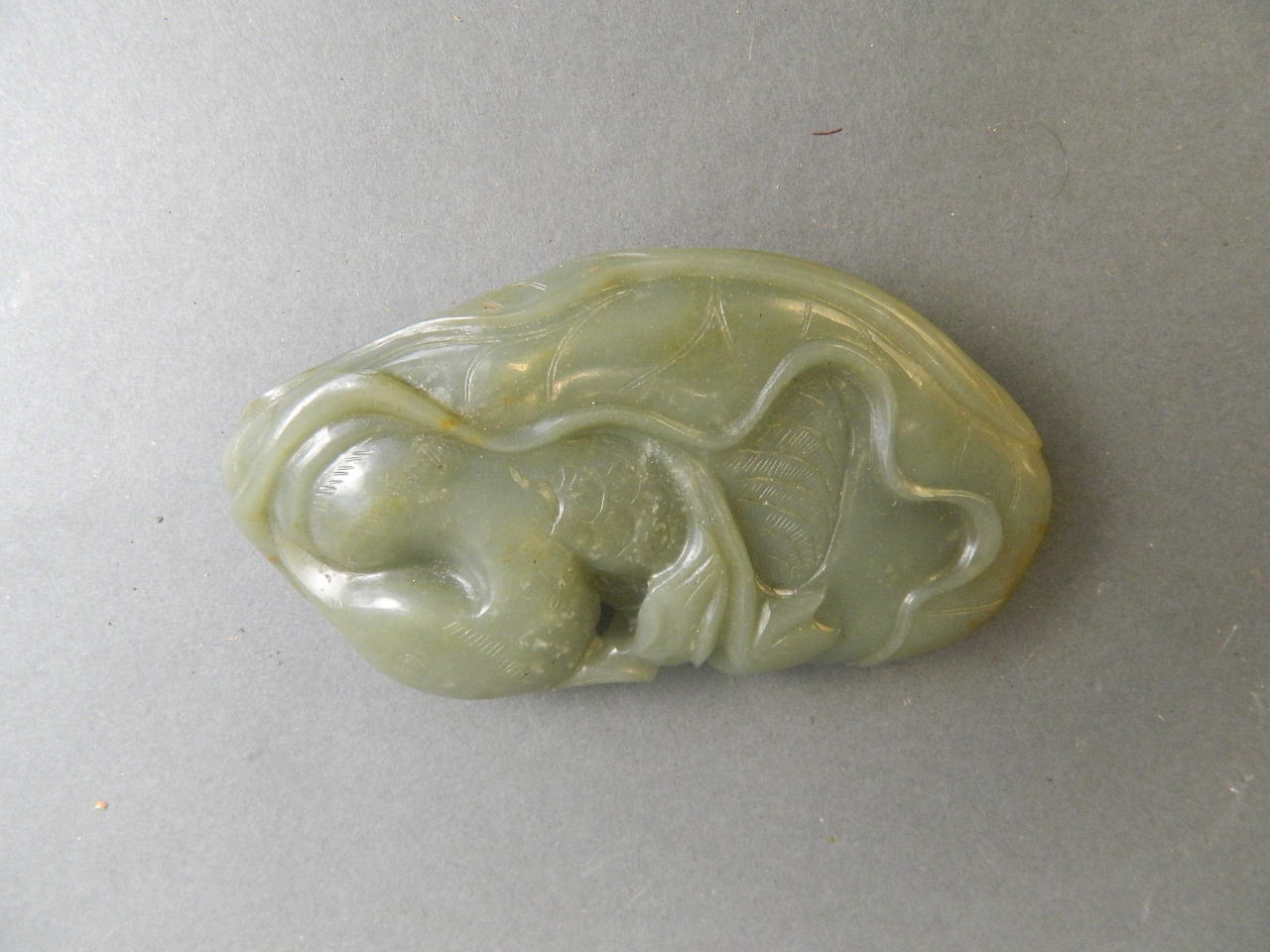 A Chinese celadon jade ornament with carved Mandarin duck decoration, 4" long