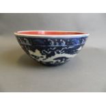 A large Chinese blue and white porcelain bowl with incised dragon decoration and a puce ground