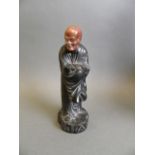 A Chinese ebonised wood figure of Lohan with a carved soapstone face, 6½" high