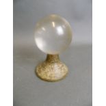 An early Chinese archaic marbled green jade stand, surmounted by a glass ball, 5" high