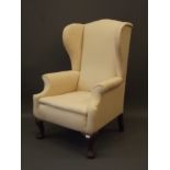 A C19th Georgian style wing back armchair (AF)