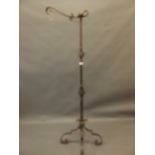 A Continental wrought iron standard lamp with twisted column, raised on shaped supports, 78" high