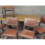 An oak refectory table with chip carved edge, and five oak dining chairs with brass studded