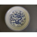 A Chinese blue and white porcelain dish decorated with a dragon chasing the flaming pearl, 6