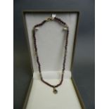 A garnet bead necklace with 9ct gold pendant, clasp and feature beads, 15" long