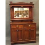An Arts & Crafts walnut dresser with mirror backed top and carved rose decoration, the base with two