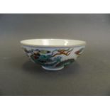 A Chinese Doucai enamelled porcelain rice bowl decorated with twin dragons chasing the flaming pearl