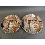 A pair of Oriental porcelain chargers decorated in the Imari style with bright enamels and panels