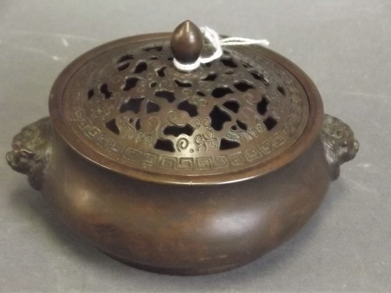 A Chinese bronze censer with pierced lid and raised lion mask handles, seal mark to base, 4½"