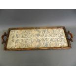 An Oriental hardwood tray with a glazed silk embroidered panel, the frame and handles carved as