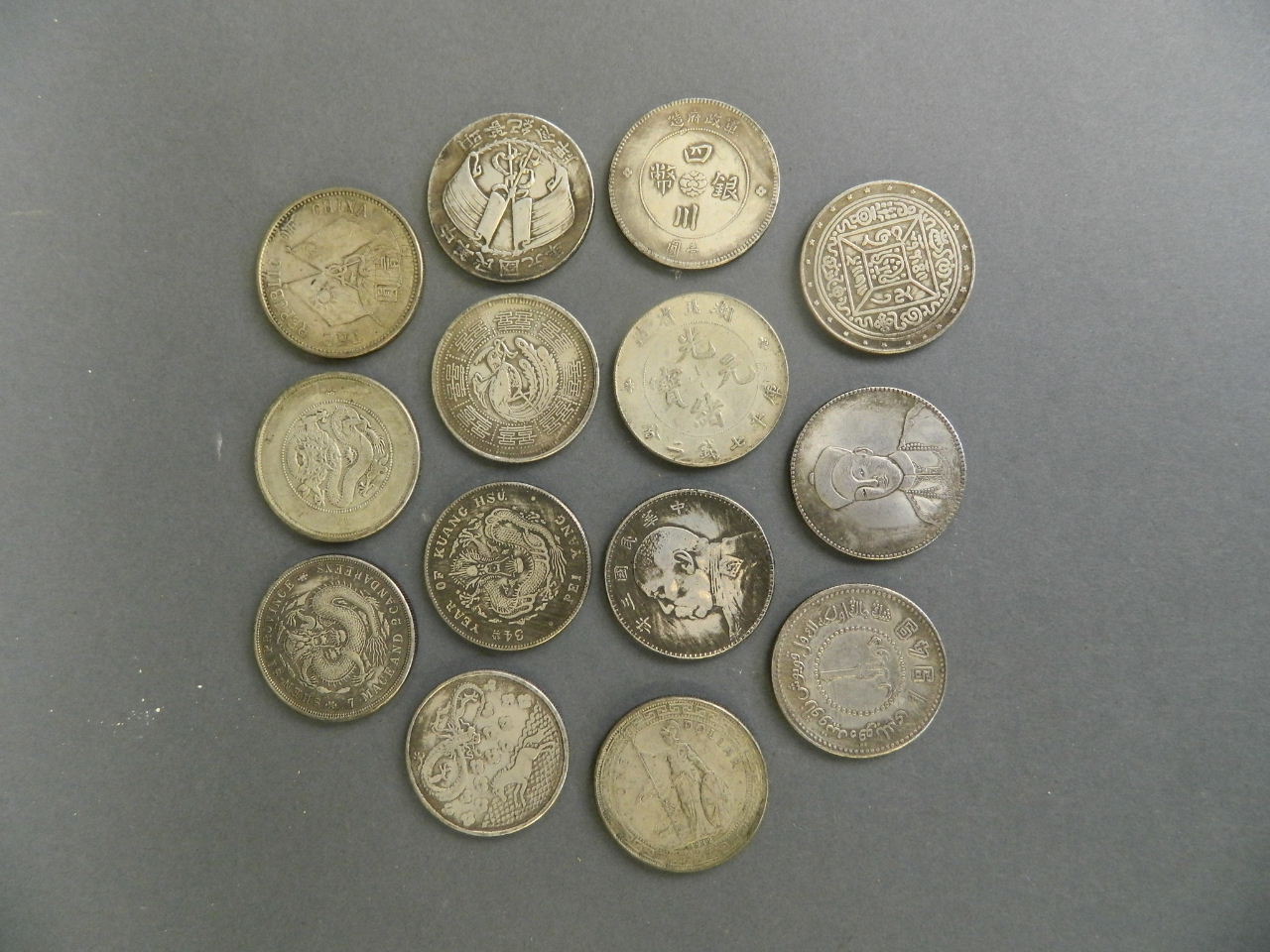 A collection of mixed metal facsimile Chinese coins, 1½" diameter (14)