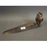 A patinated brass inkwell In the form of an owl with a feather shaped pen tray, 13½" long (lacks