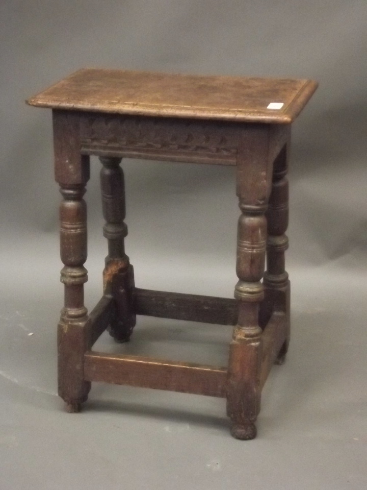 An early C17th oak joynt stool with chip carved frieze, raised on turned splayed supports