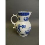 An early Worcester porcelain jug with mask spout and blue and white decoration of a parrot and