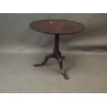 A Georgian style mahogany tilt-top occasional table with a one piece pie crust top, raised on a