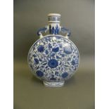 A Chinese blue and white porcelain moon flask with twin elephant mask handles and scrolling lotus