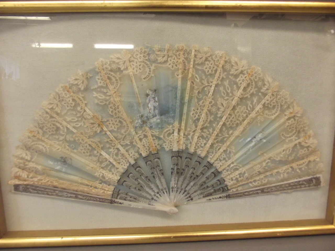 A C19th lace and mother of pearl fan painted with cherubs, framed, fan 11½" long