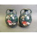 A matched pair of Continental green ground porcelain vases with twin handles and enamel decoration