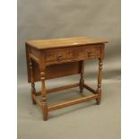 An oak two drawer side table with carved decoration and drop leaf, 30" x 17" x 29"