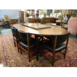 An Archie Shine Indian rosewood oval shaped dining table with two extra leaves, and a set of eight