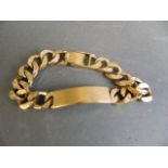 A 9ct gold gentleman's flat curb link identity bracelet with bark finish, 63g