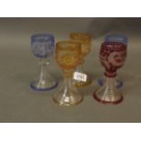 A set of five C19th Bohemian coloured drinking glasses with fine engraved decoration of hounds