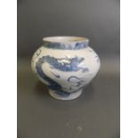 A Chinese Ming style blue and white pottery jardinière with painted decoration of a dragon chasing