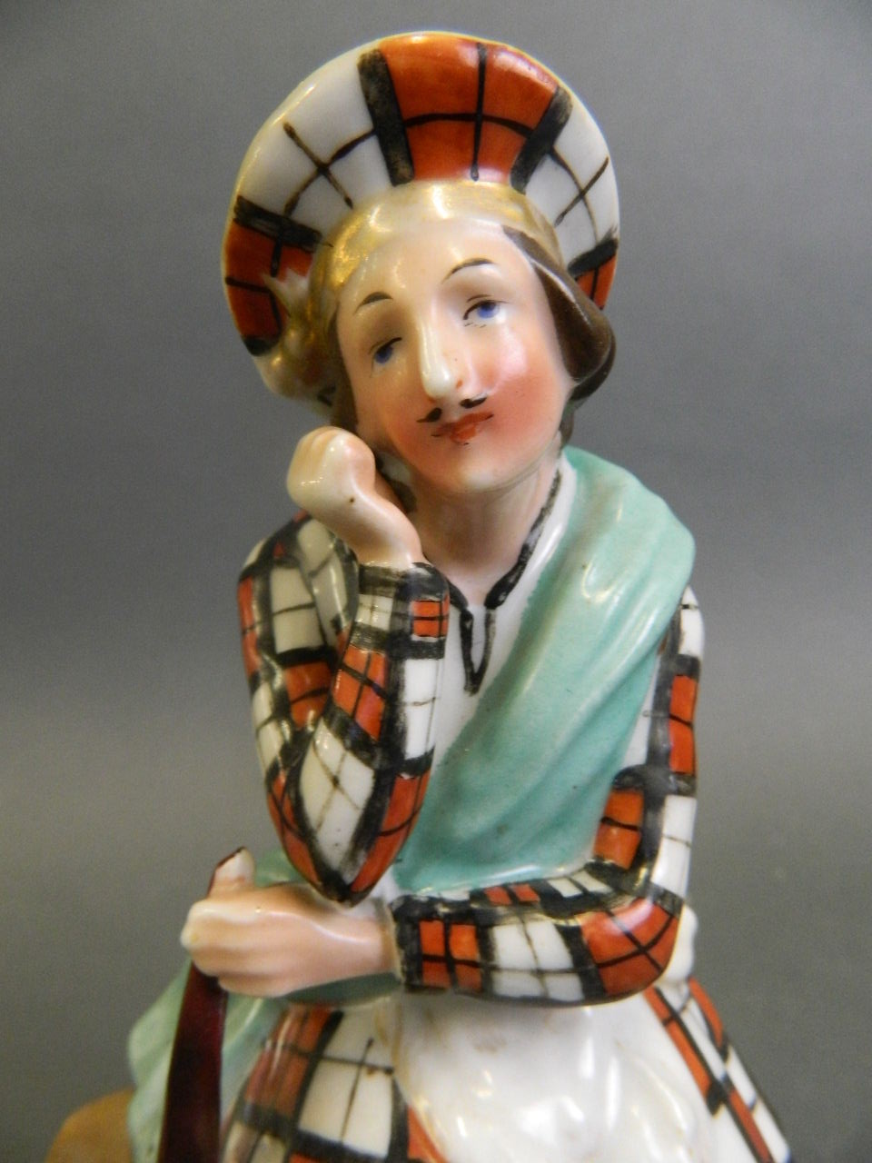 A porcelain figure of a Scottish highlander seated on a rock with a small dog asleep at his feet, - Image 4 of 4