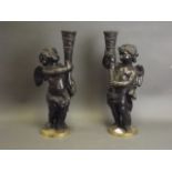 A pair of late C19th/early C20th bronze lamps in the form of cherubs bearing cornucopia, 15½" high