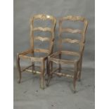 A pair of French carved oak ladderback side chairs, lack seats