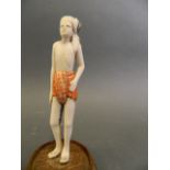 An Oriental carved ivory figure of a man wearing a loincloth and turban, 5" high