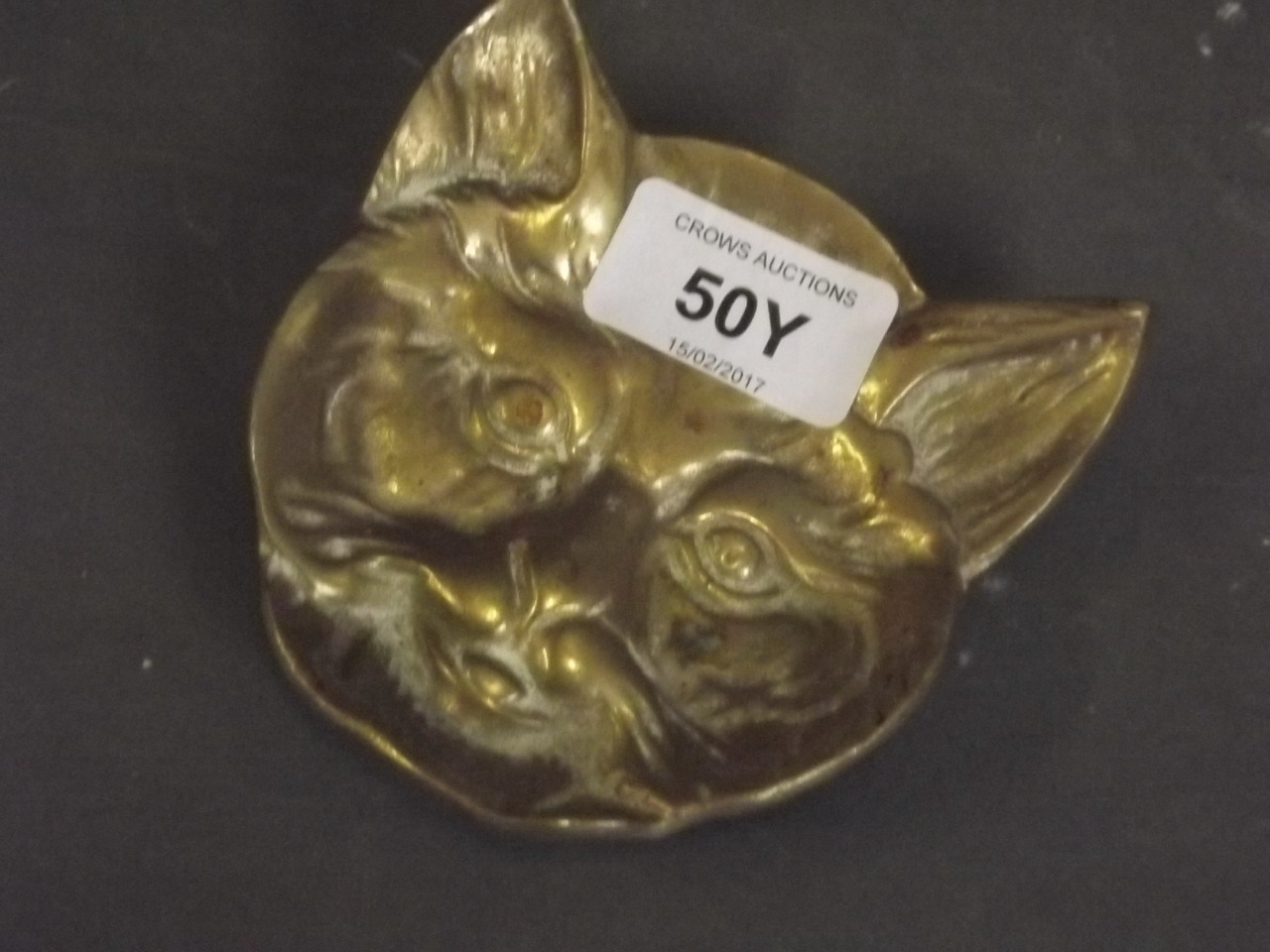 A brass ashtray in the form of a cat's head, 4" long