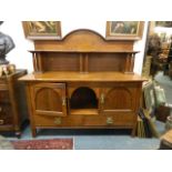 An Arts & Crafts inlaid oak dresser, the dome topped upper section and shelf supported by columns